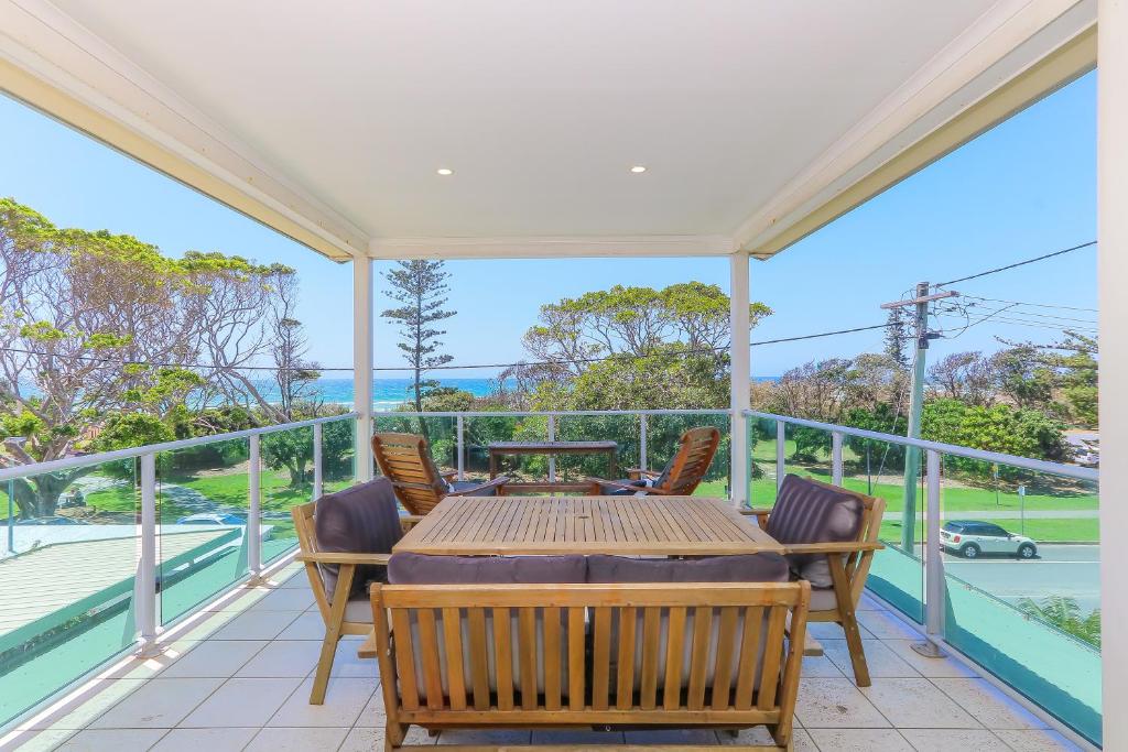 a dining room with a table and chairs on a balcony at Ocean View Apartments by Kingscliff Accommodation in Kingscliff