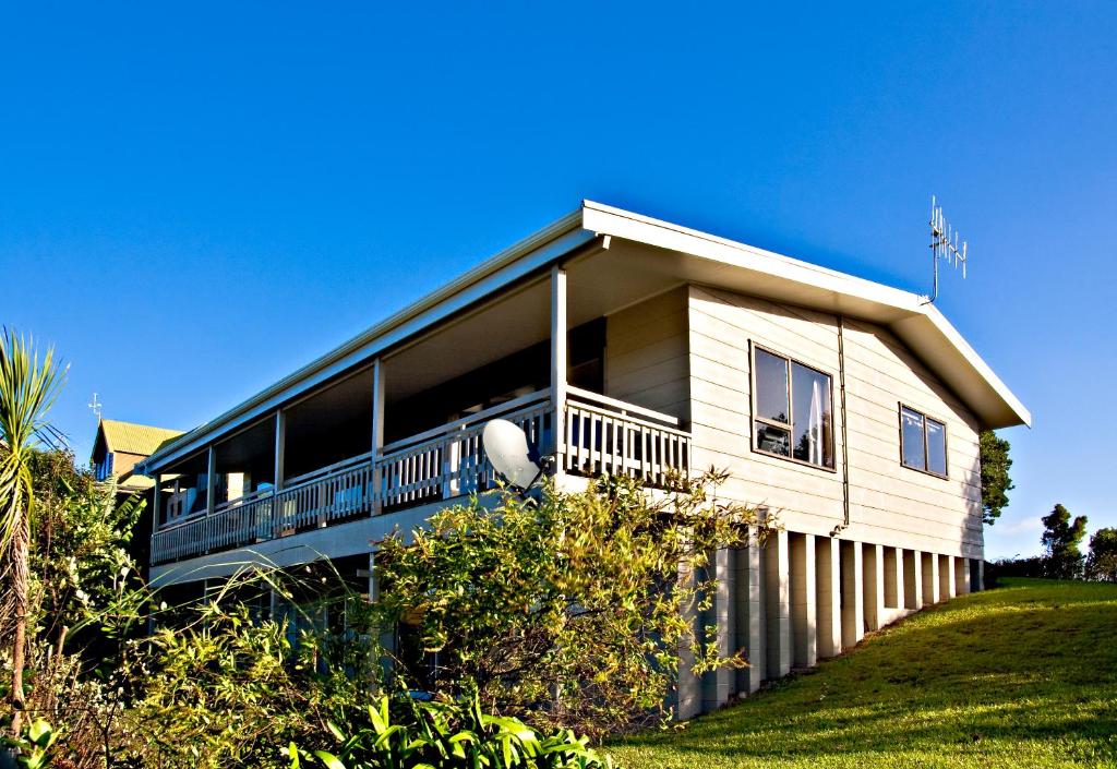 a house with a large balcony on the side of it at High Tides in Ngunguru