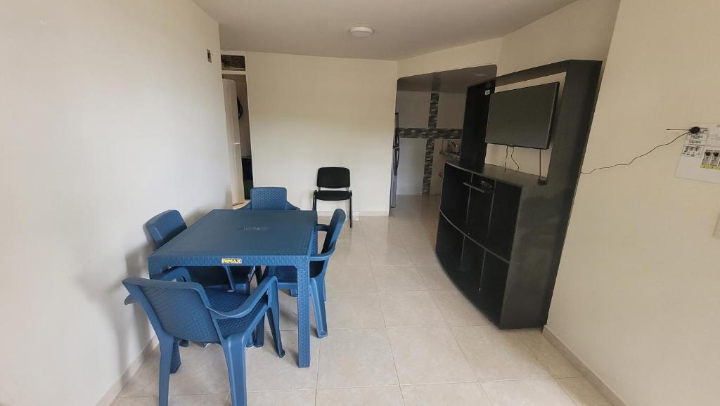 Zimmer mit einem blauen Tisch und Stühlen sowie einem TV in der Unterkunft Apartamento cool Neiva in Neiva