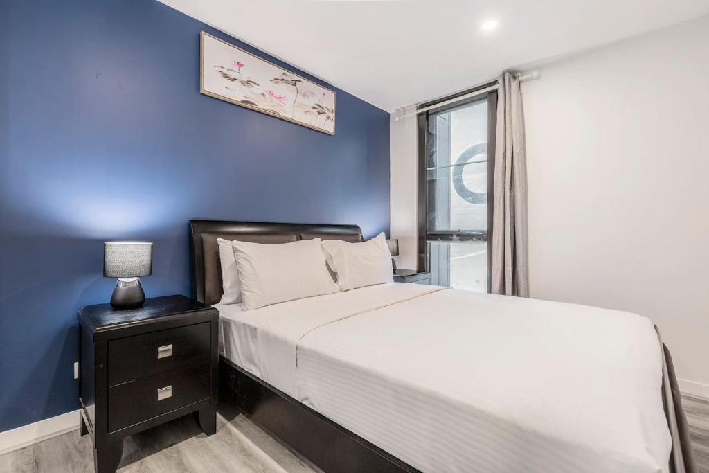 a bedroom with a large bed and a blue wall at Effortless Local Living on Greville Street in Melbourne