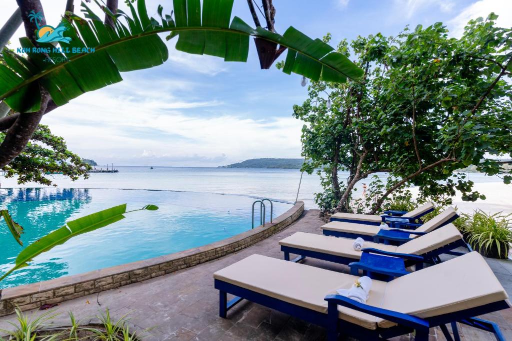 a group of lounge chairs next to a swimming pool at Koh Rong Hill Beach Resort in Koh Rong Island