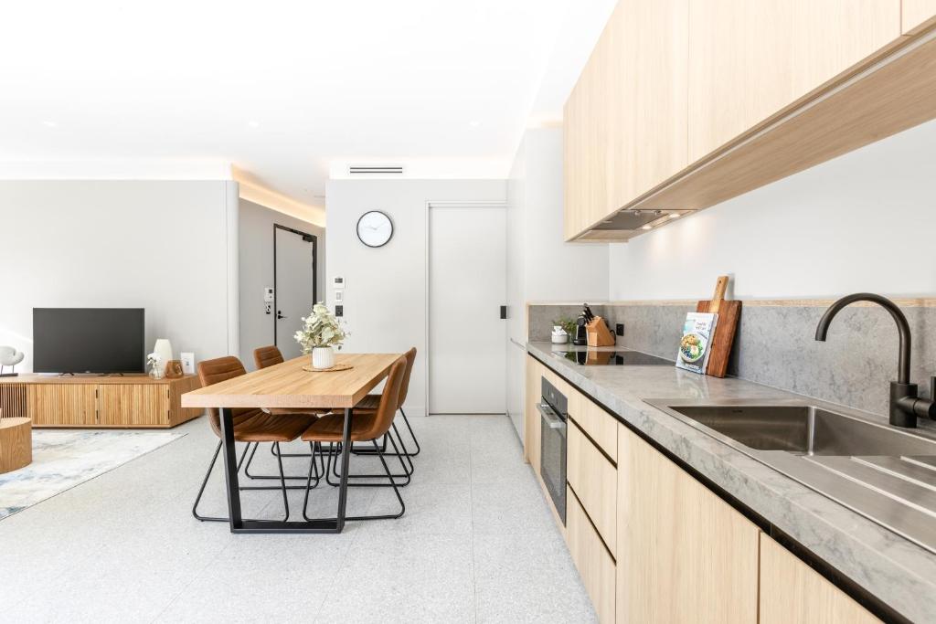 kuchnia z drewnianym stołem i zlewem w obiekcie The 249 Apartments by Urban Rest w mieście Sydney