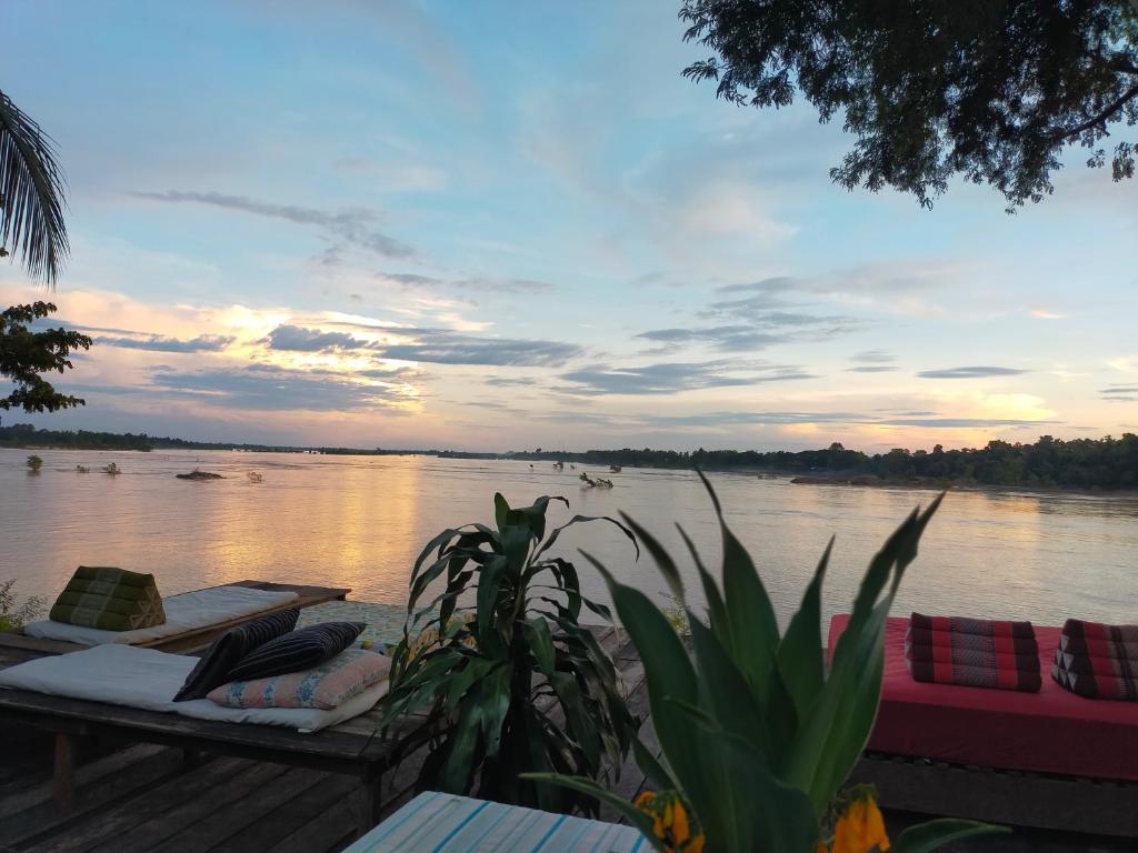 vistas a un río con barcos en el agua en Pomelo Restaurant and Guesthouse- Serene Bliss, Life in the Tranquil Southend of Laos, en Ban Khon