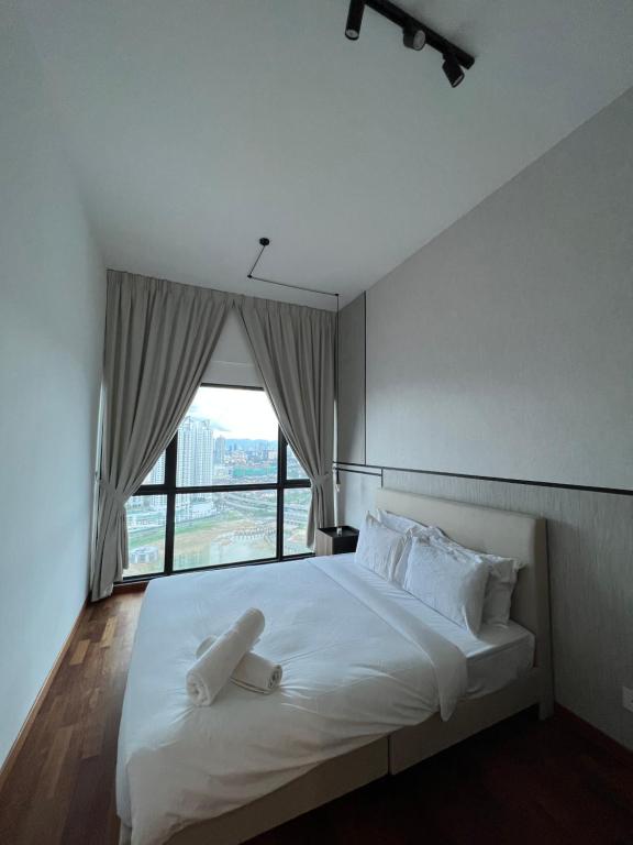 a bedroom with a large white bed with a window at Reizz Residence By Classy in Kuala Lumpur