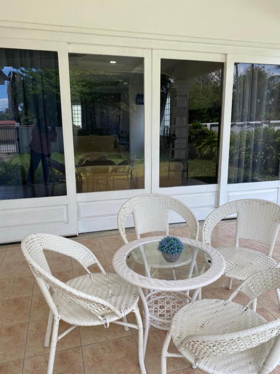 a group of white chairs and a glass table and chairs at Kuala Terengganu Newly Renovated Nenda Beach House in Kuala Terengganu