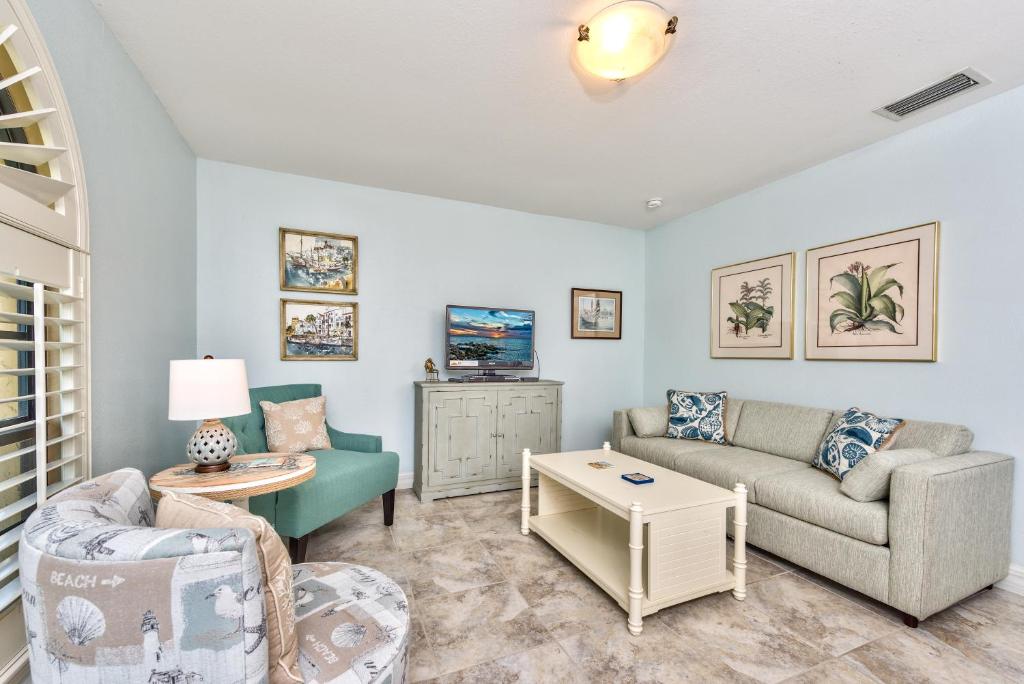 a living room with a couch and a table at Le Monaco Condo at Olde Naples in Naples