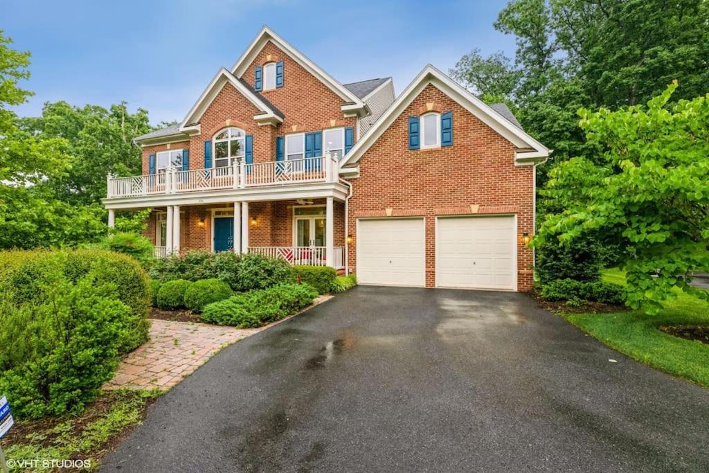 a brick house with a garage on a driveway at Luxury Retreat with Family Feel: Perfect Getaway! in Leesburg