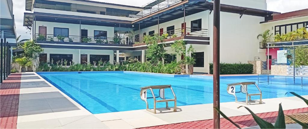 a swimming pool in front of a building at MaClare Resort in Imus