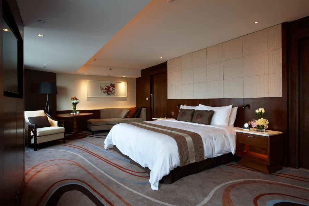 a hotel room with a large bed and a living room at White Swan Hotel in Guangzhou