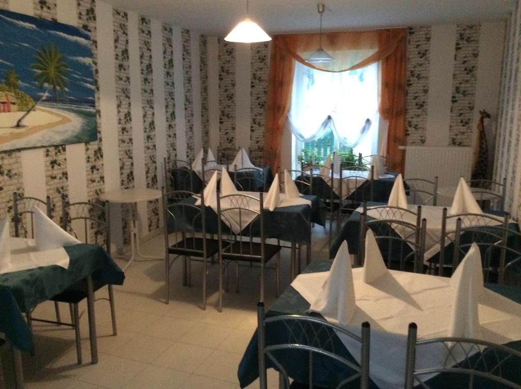 a dining room with tables and chairs and a window at Blumenhotel in Bergneustadt