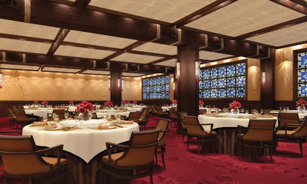 a dining room with tables and chairs and windows at White Swan Hotel in Guangzhou
