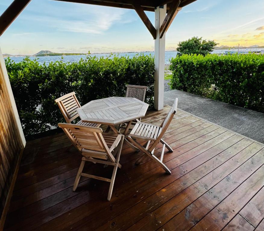einen Tisch und Stühle auf einer Terrasse mit Meerblick in der Unterkunft The little Heaven in Baie Nettle