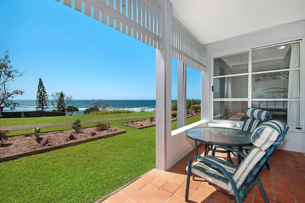 a patio with a table and chairs and a view of the ocean at Quarterdeck 5 in Lennox Head
