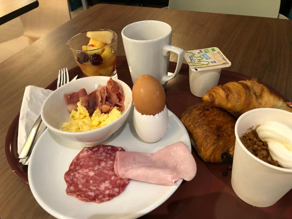 a table with a plate of breakfast food on it at KYRIAD HONFLEUR - La Riviere Saint Sauveur in Honfleur