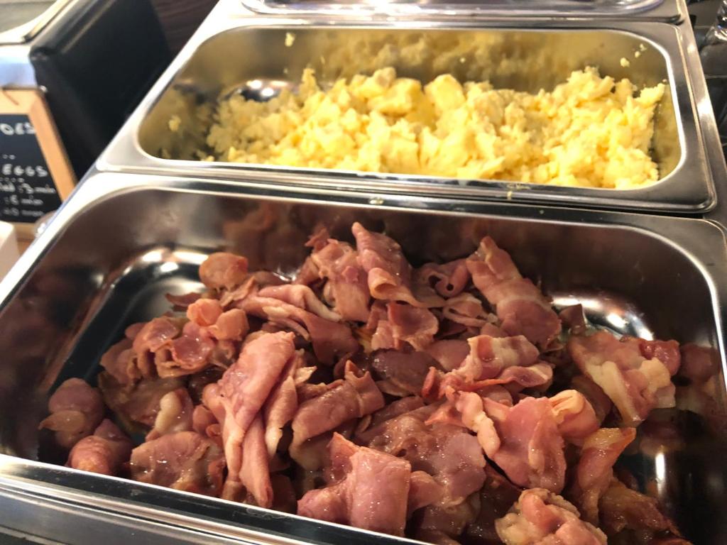 a tray of food with bacon and scrambled eggs at KYRIAD HONFLEUR - La Riviere Saint Sauveur in Honfleur