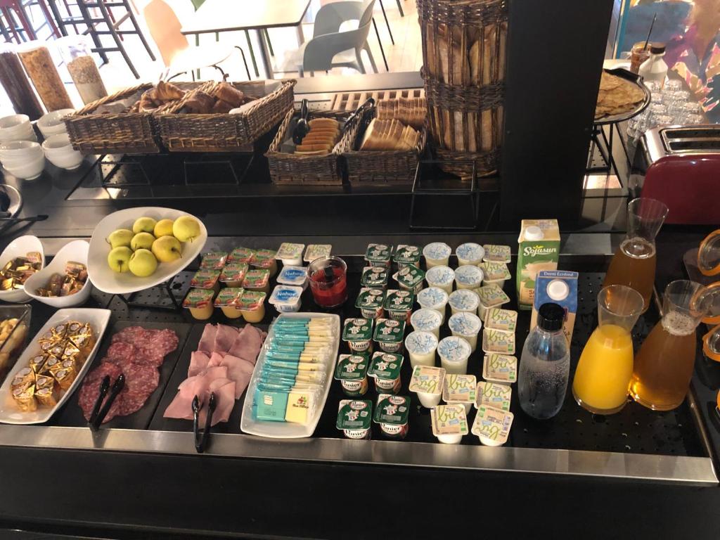 a buffet with various foods and drinks on a table at KYRIAD HONFLEUR - La Riviere Saint Sauveur in Honfleur