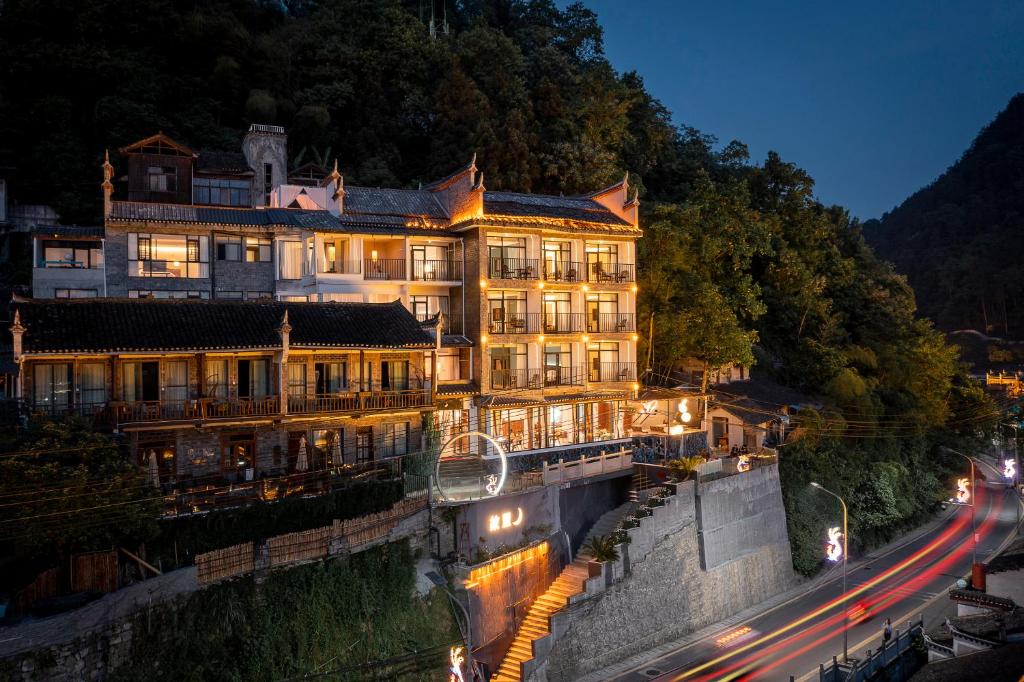 a large building on the side of a river at night at Phoenix Best River View B&B in Fenghuang