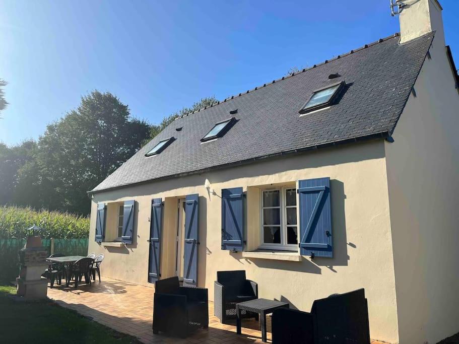 une maison avec volets bleus, table et chaises dans l'établissement Gîte la Villemain, à Saint-Broladre