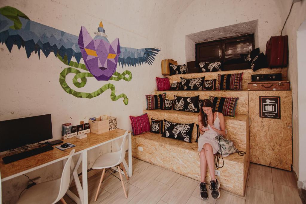 eine Frau auf einer Couch in einem Zimmer mit einem Schreibtisch in der Unterkunft Way Kap Hostel Arequipa in Arequipa