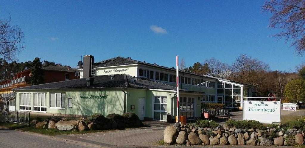 un edificio con una señal delante de él en Pension Dünenhaus, en Zempin
