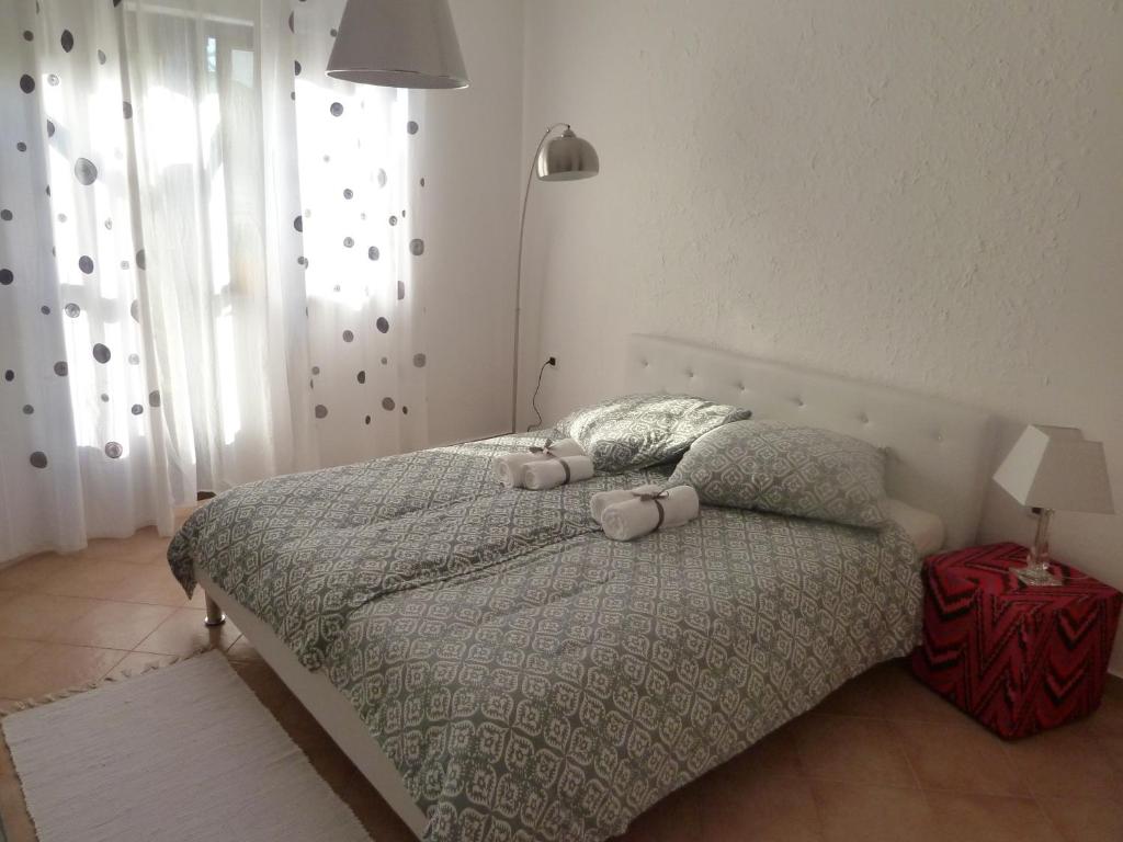 a bedroom with a bed with two pillows on it at Rose Apartments in Ičići