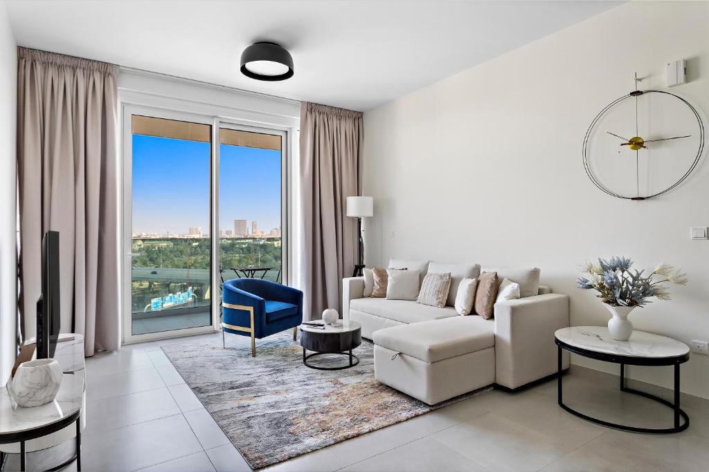 a living room with a white couch and a large window at Spacious 1BR APT Wasl in Dubai