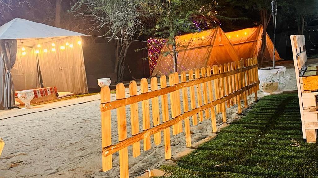 una valla de madera en un patio trasero por la noche en ONE 7 FARM (DESI PARADISE FARM ) en Dubái