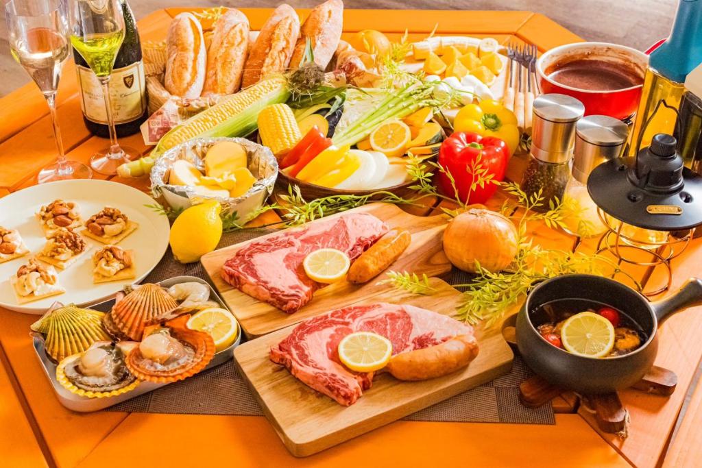 una mesa con un buffet de comida en una mesa en 由布院温泉グランピング　風の響き, en Yufu
