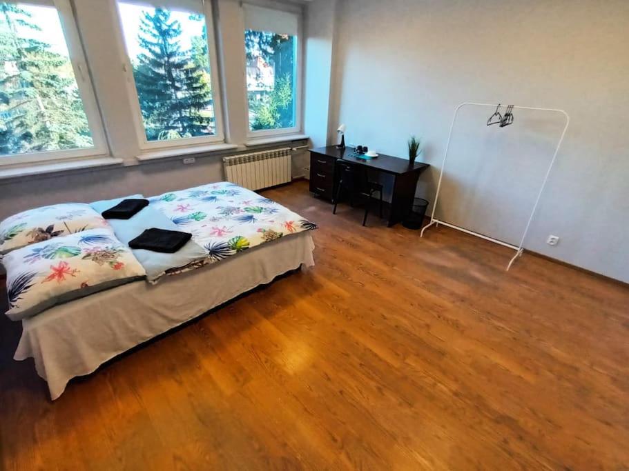 Schlafzimmer mit einem Bett, einem Schreibtisch und Fenstern in der Unterkunft Fantastic ZG - S4 Pokój 207 in Zielona Góra