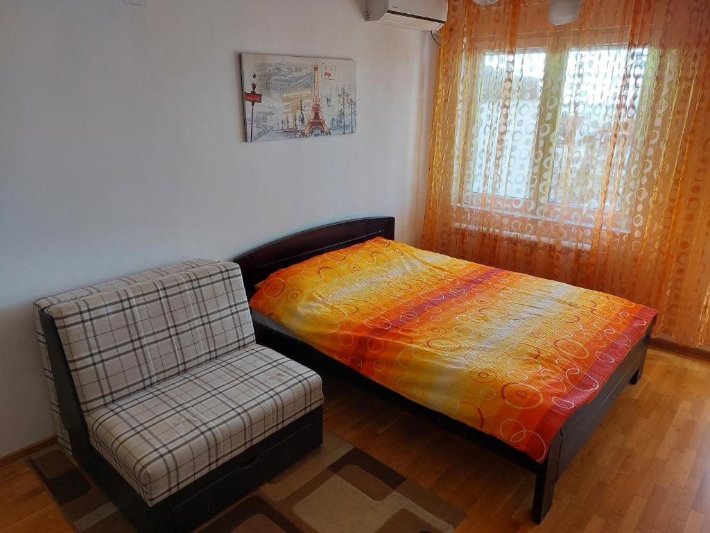 a bed and a chair in a room at Sweet Apartment in Belgrade