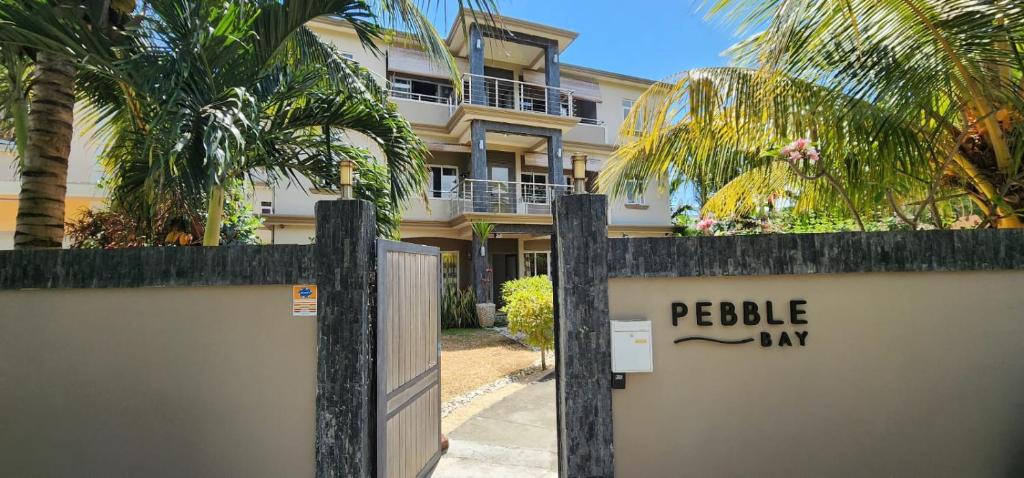 um sinal numa vedação em frente a um edifício em Number 5, Pebble Bay Appartments em Grand Baie