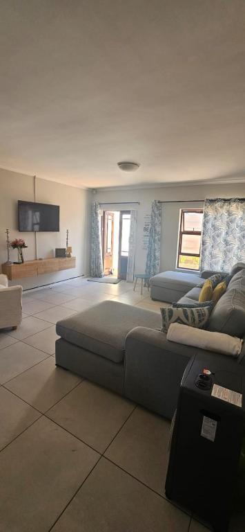 a living room with two beds and a couch at Quaint Family home, walking distance to the beach in Cape Town