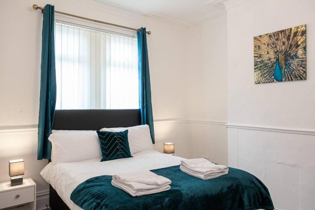 a bedroom with a bed with two towels on it at Inspired Stays- City Centre- Spacious 4 Bed House! in Stoke on Trent