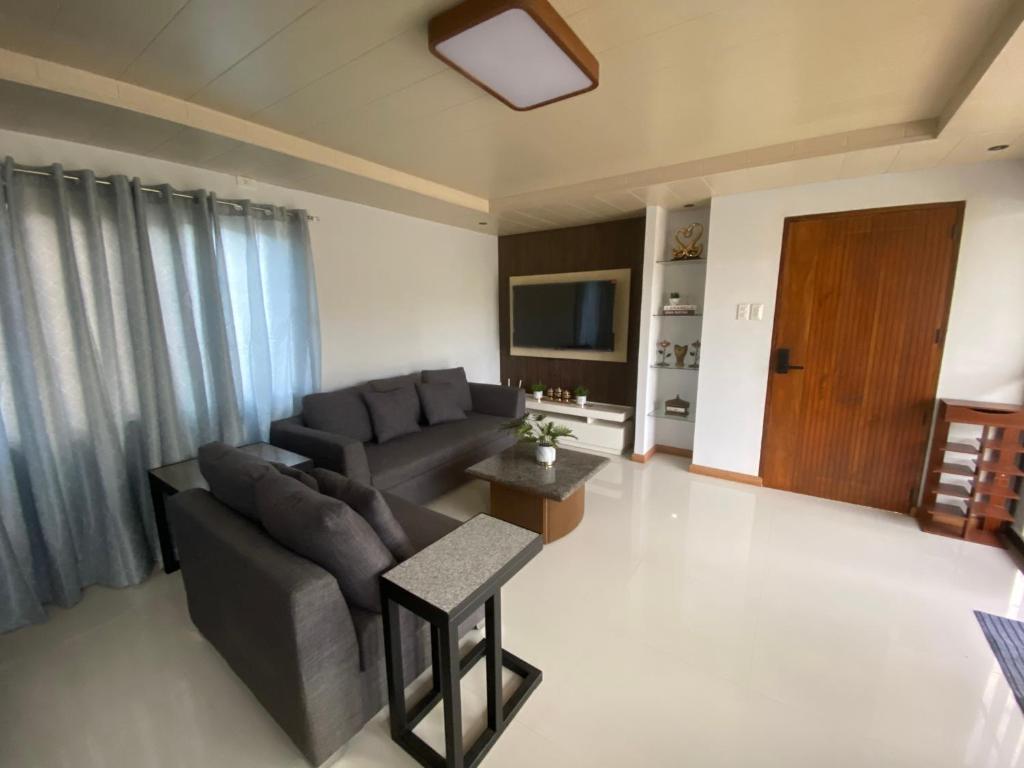 ein Wohnzimmer mit einem Sofa und einem TV in der Unterkunft Jill’s Maison in Malawin