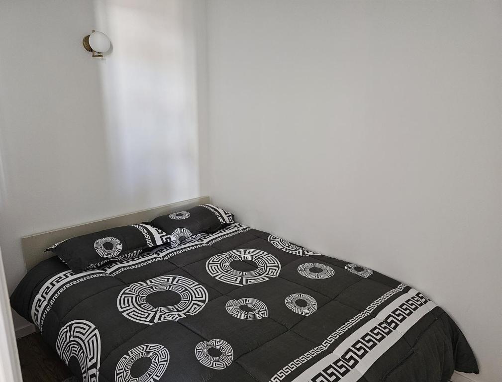 - un lit avec une couverture et des oreillers noirs et blancs dans l'établissement Massilia New'z appart 02, à Marseille