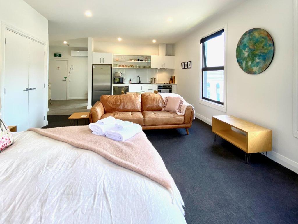 a room with a bed and a couch and a kitchen at Nelson City Centre Apartment 1 in Nelson