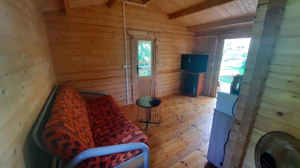 an empty room with a couch in a log cabin at Chalet de la Mer Cassée in Saint-Philippe