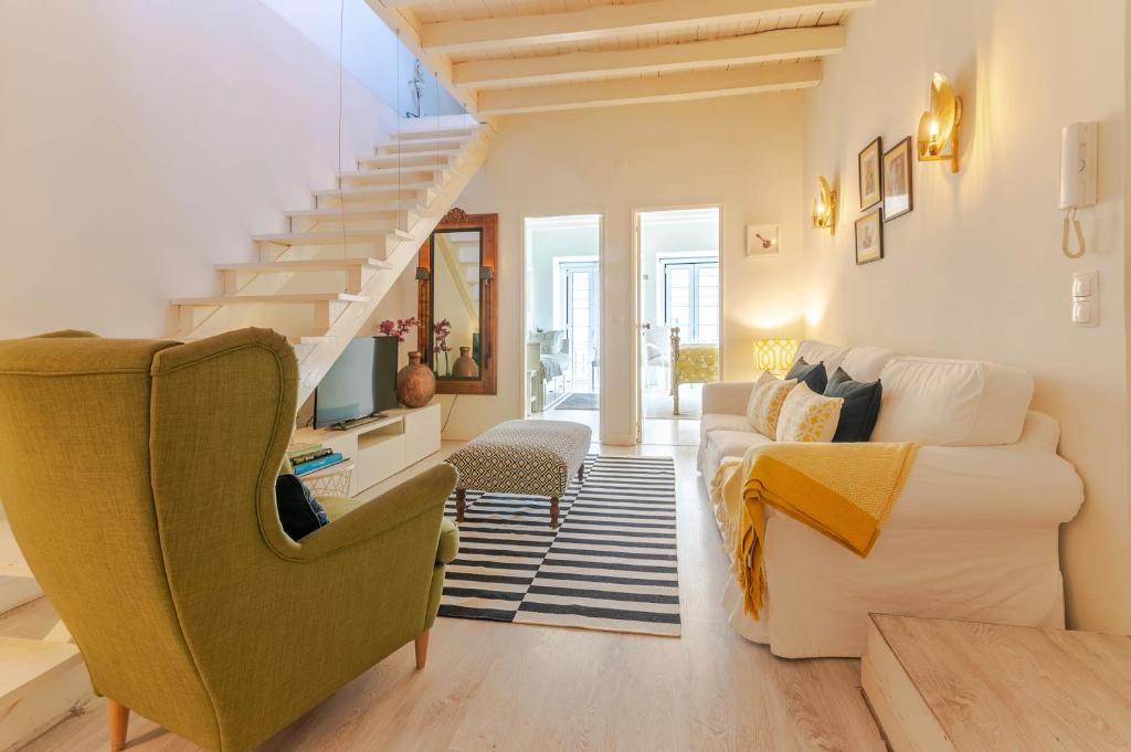 een woonkamer met een bank en een trap bij Sunny São Paulo Home in Lissabon