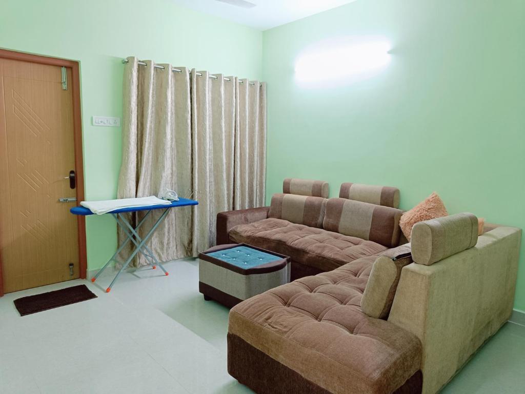 Ananya service apartments في تشيناي: غرفة معيشة مع أريكة وطاولة