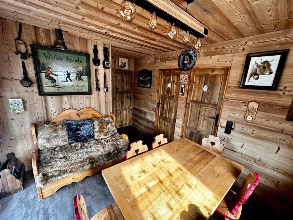 a room with a bed and a wooden table at l'écureuil in Saint-Laurent-en-Grandvaux