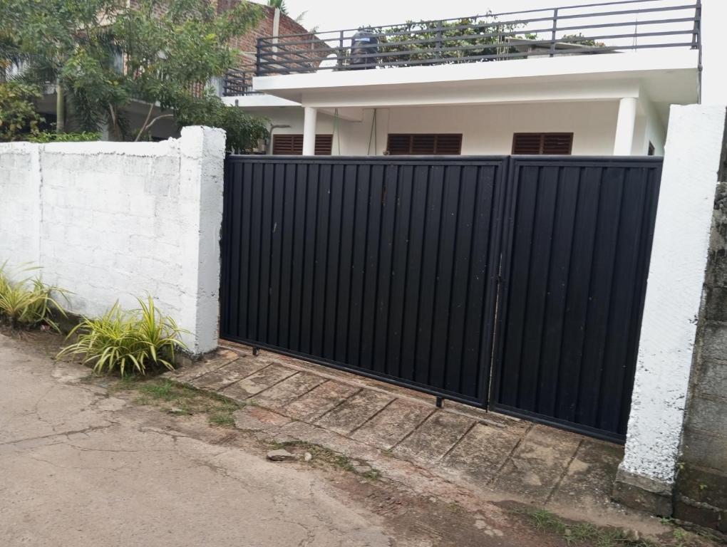 a black fence in front of a house at Anne's Homestay in Gampaha