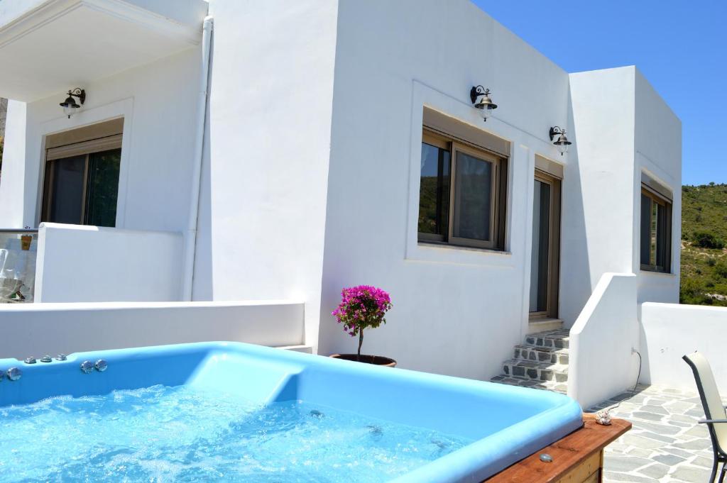 a white house with a blue tub on a patio at Bianca Suite & Home in Psinthos