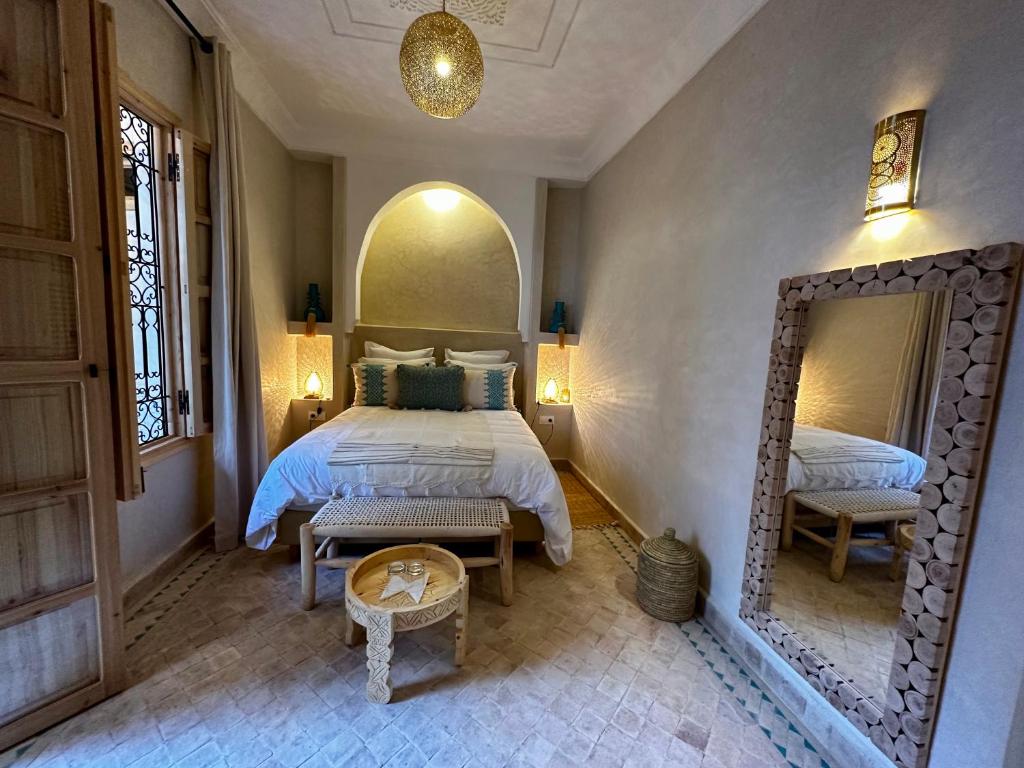 a bedroom with a large bed and a mirror at Riad Citrus in Marrakech
