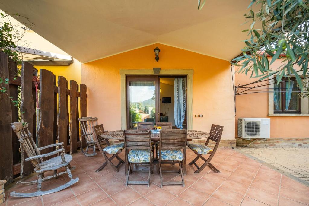 a patio with a wooden table and chairs at Casa Vacanze L'olivo in Olìa Speciosa