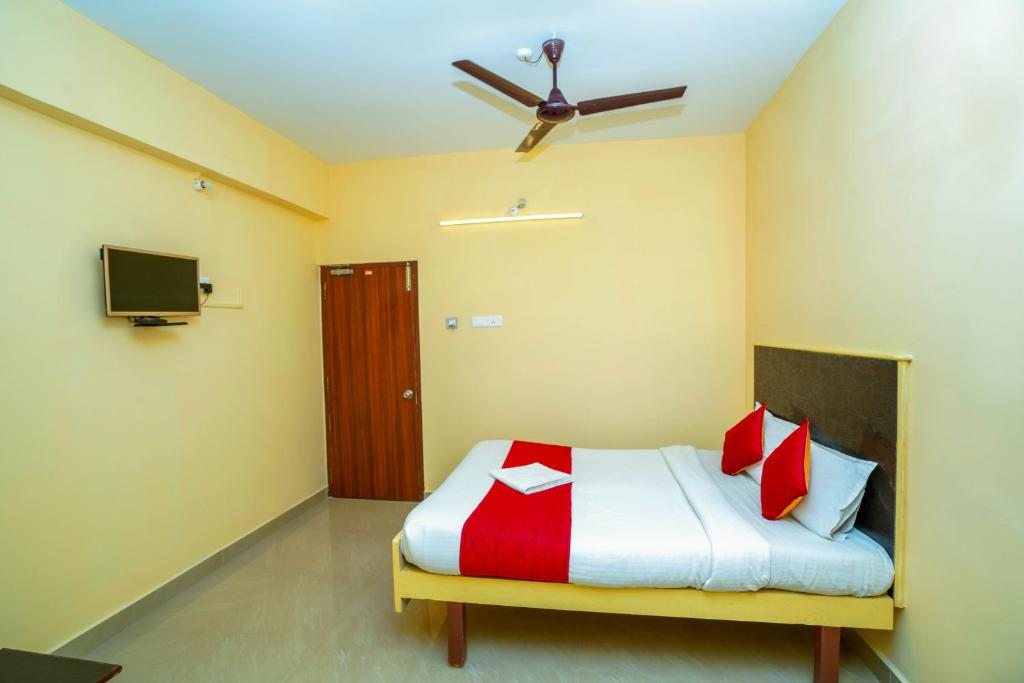 a bedroom with a bed with a ceiling fan at Ssunshhine residency (NEW) in Tirupati