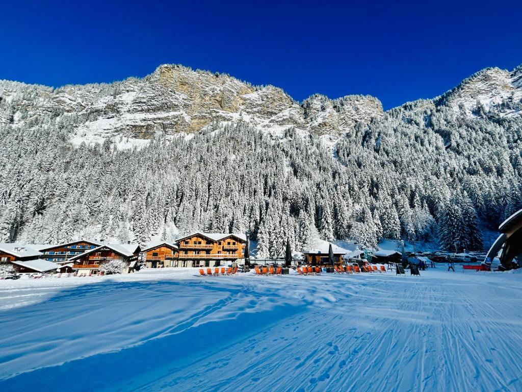 a resort with snow covered mountains in the background at Hameau des Prodains - Résidence in Morzine