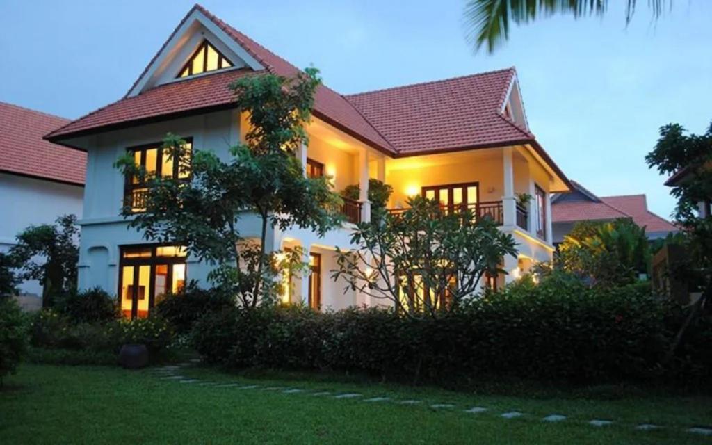 a large white house with lights on at Da Nang Beach Villas in 5-star Resort in Da Nang