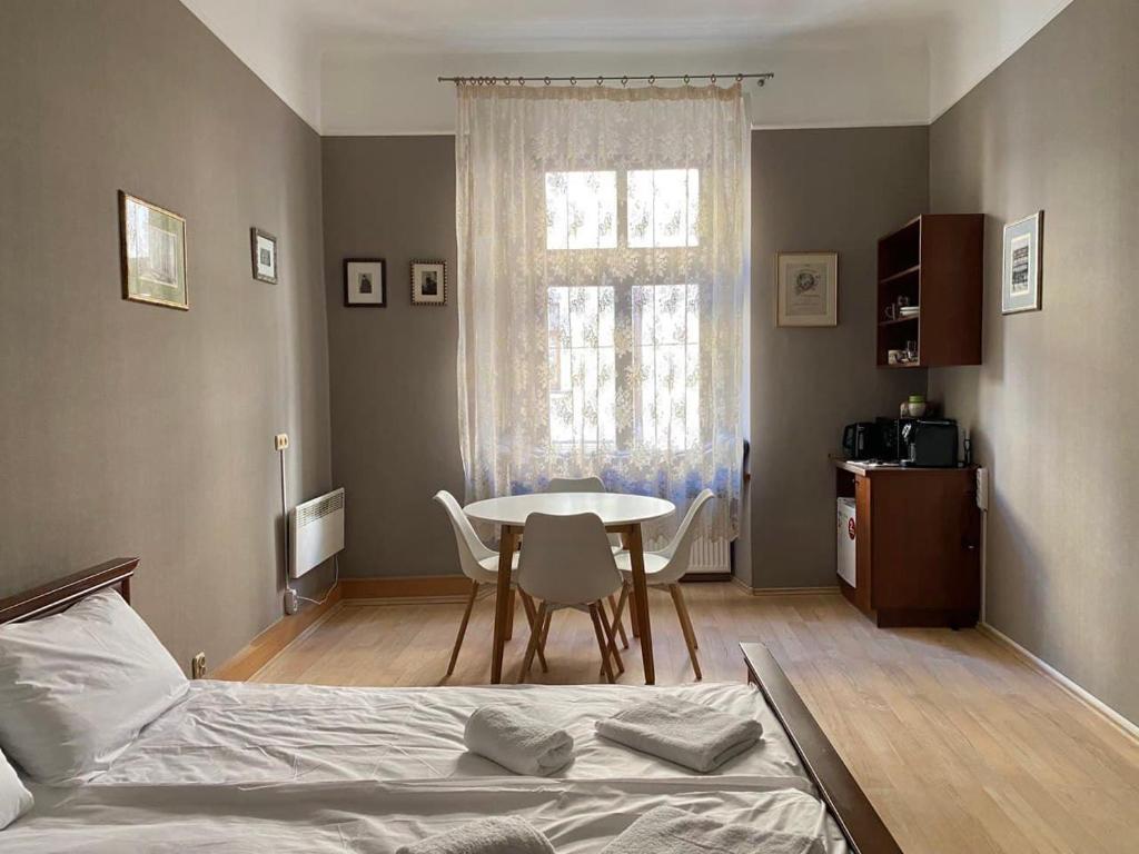 a bedroom with a bed and a table and chairs at Freska Apartments in Lviv