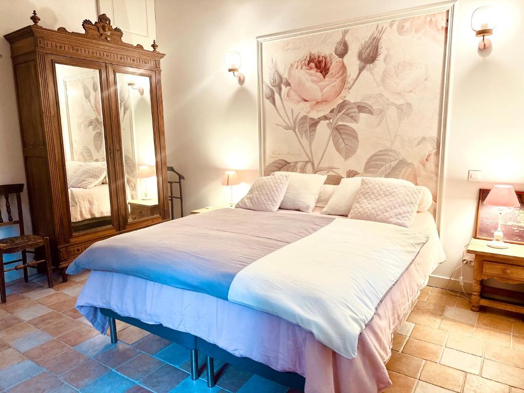 a bedroom with a large bed with a painting on the wall at Le Pavillon Vert - B&B in Vedène