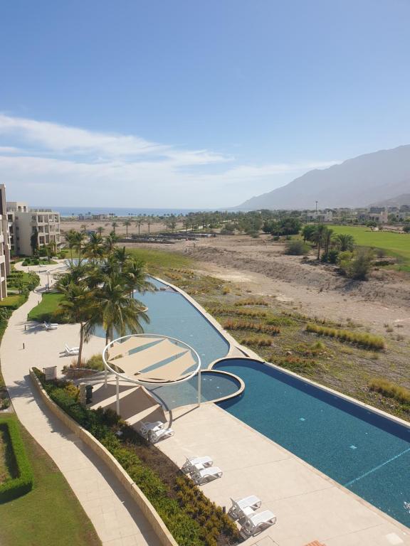 an aerial view of a swimming pool at a resort at Golf Lake Penthouse in As Sīfah